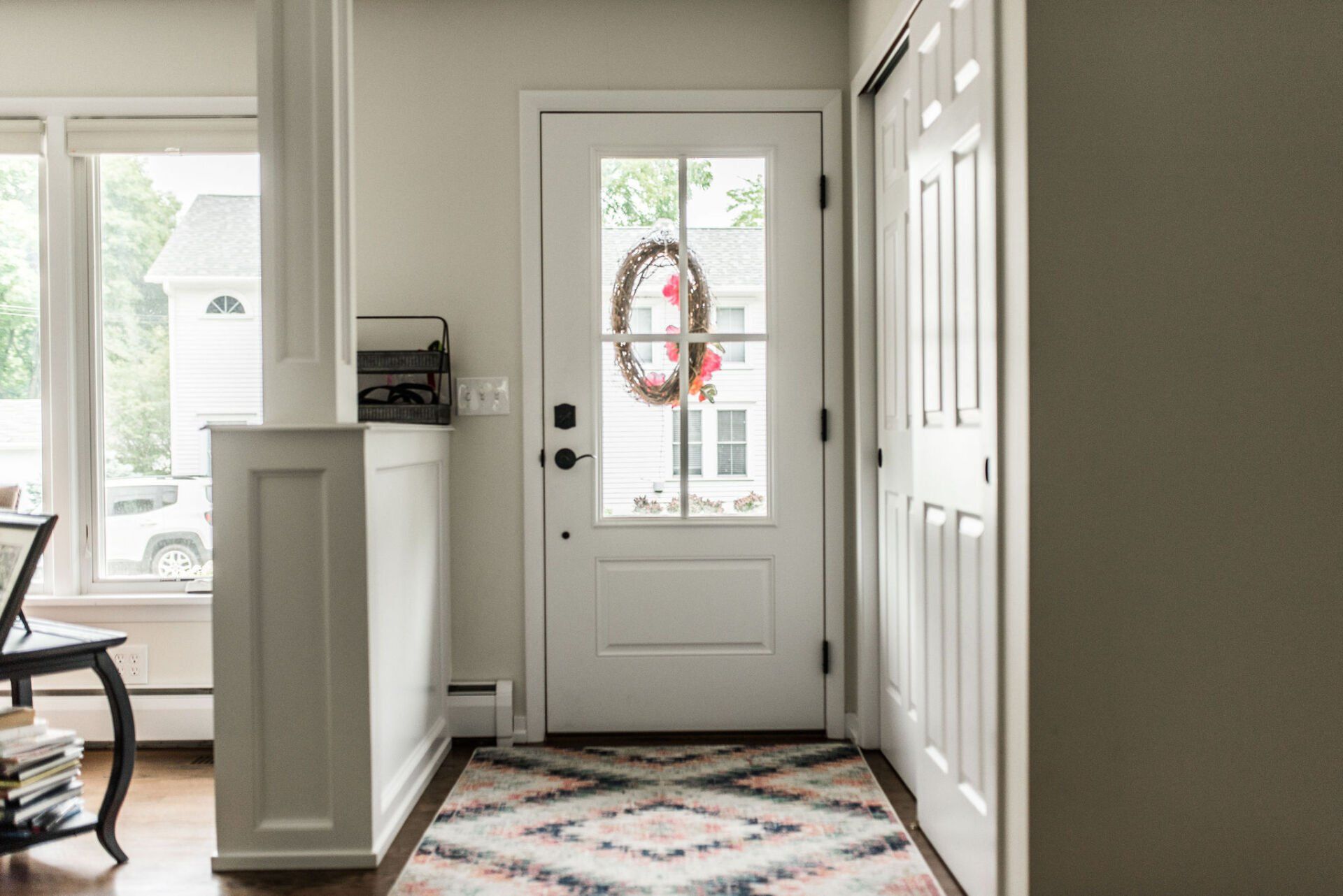 A white door with a wreath on it is in a hallway.