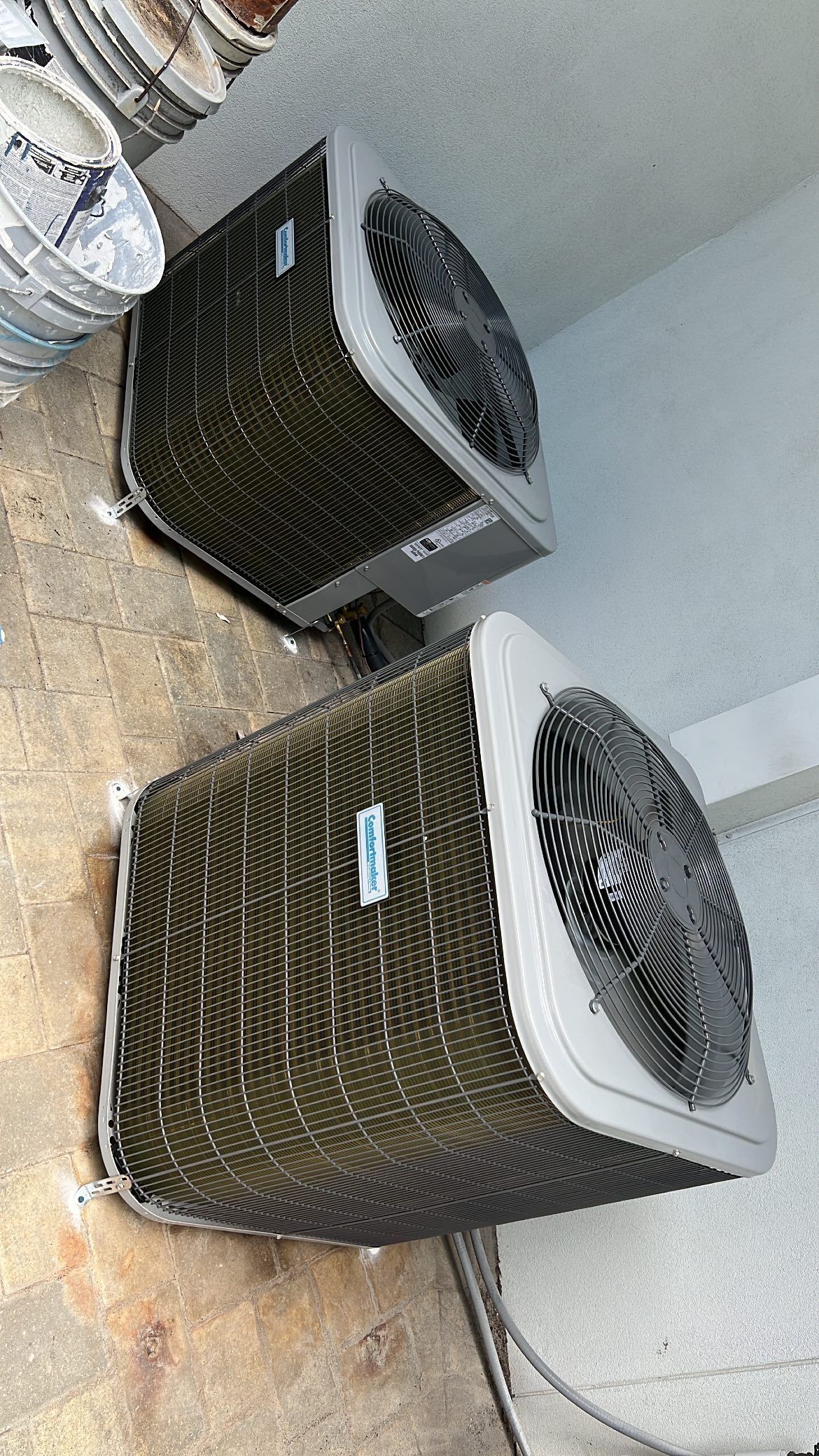 two air conditioners are sitting on top of a wooden table .
