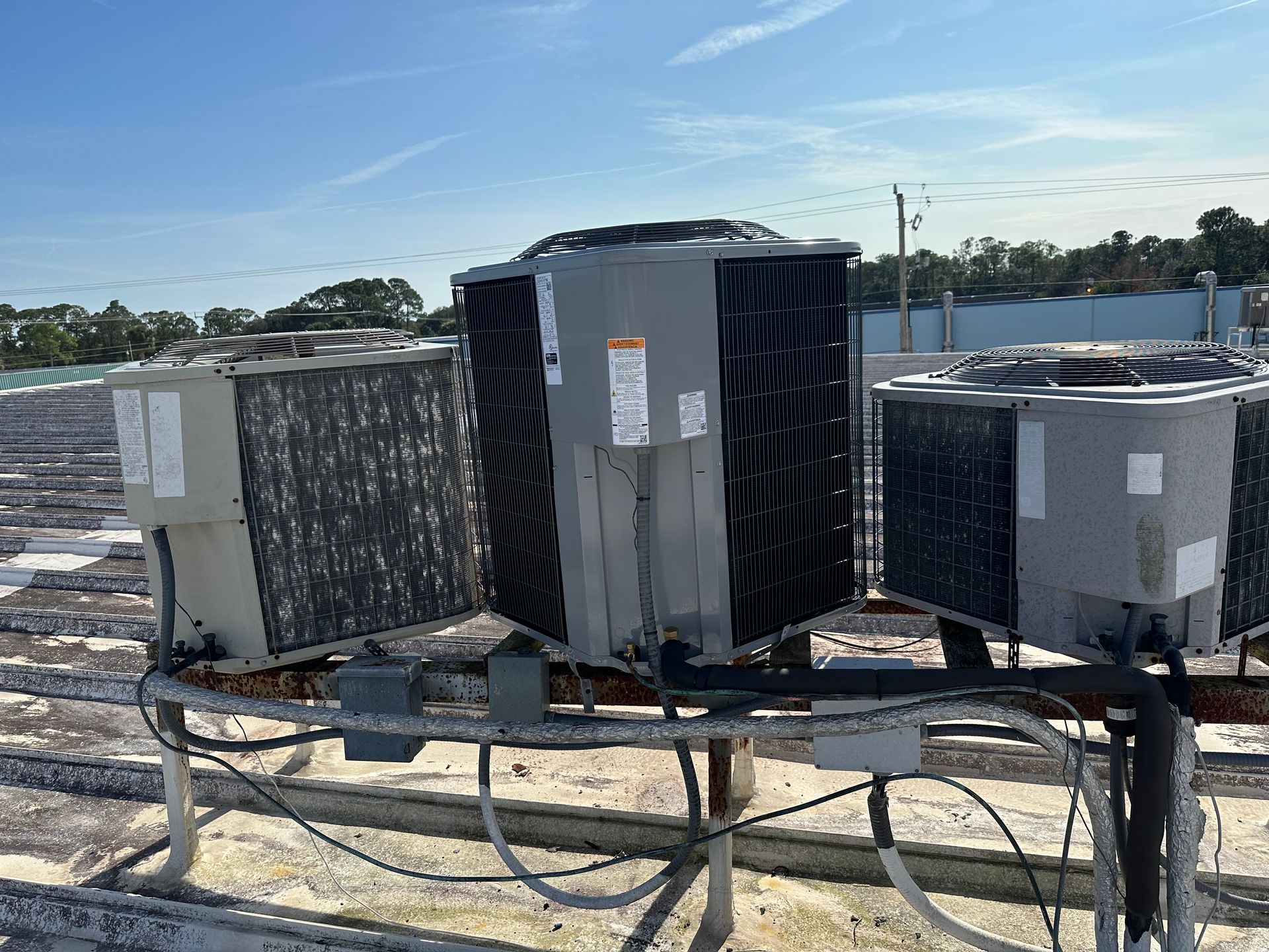 a bunch of air conditioners are sitting on top of a roof .