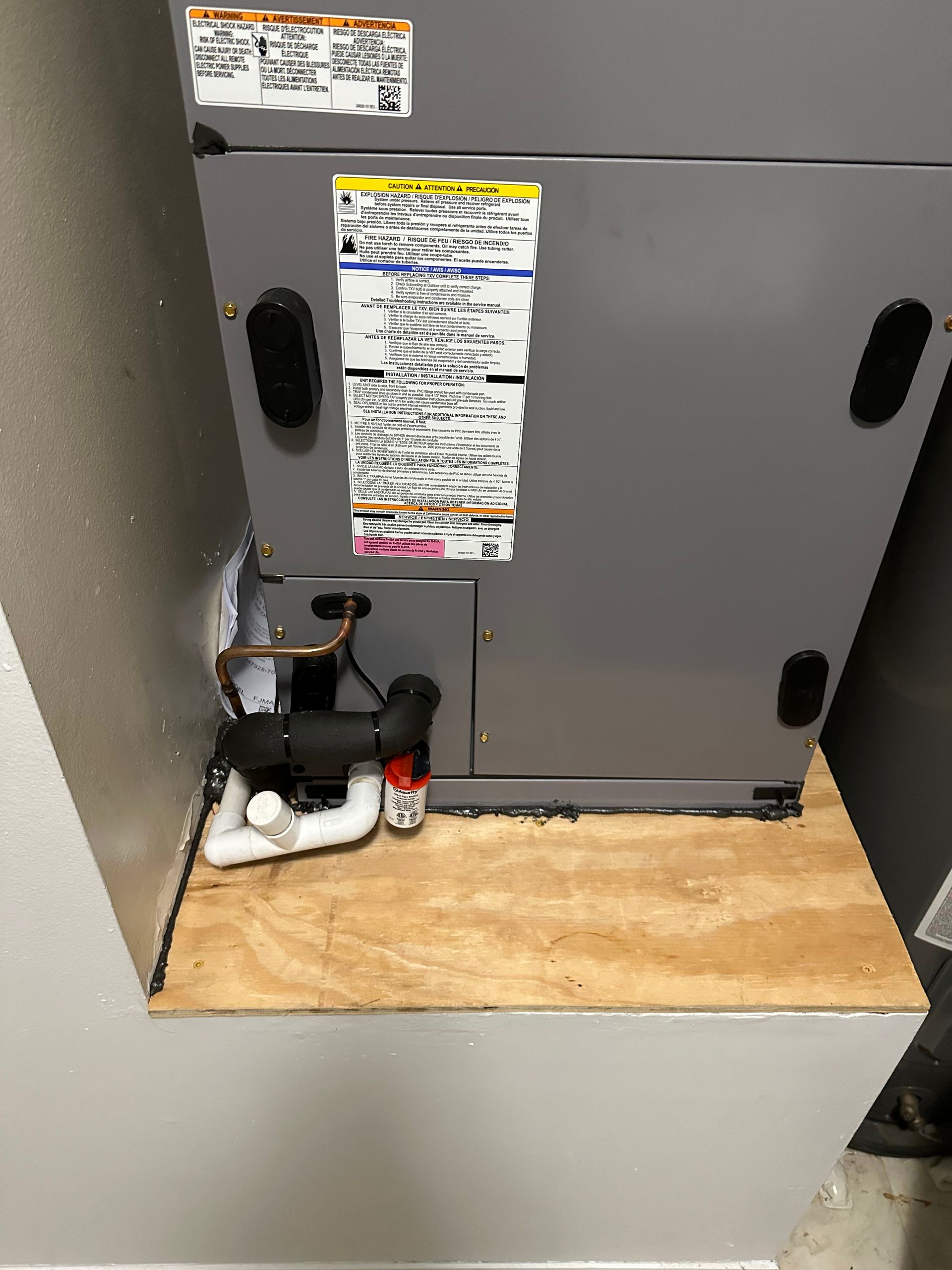 a furnace is sitting on top of a wooden shelf in a room .