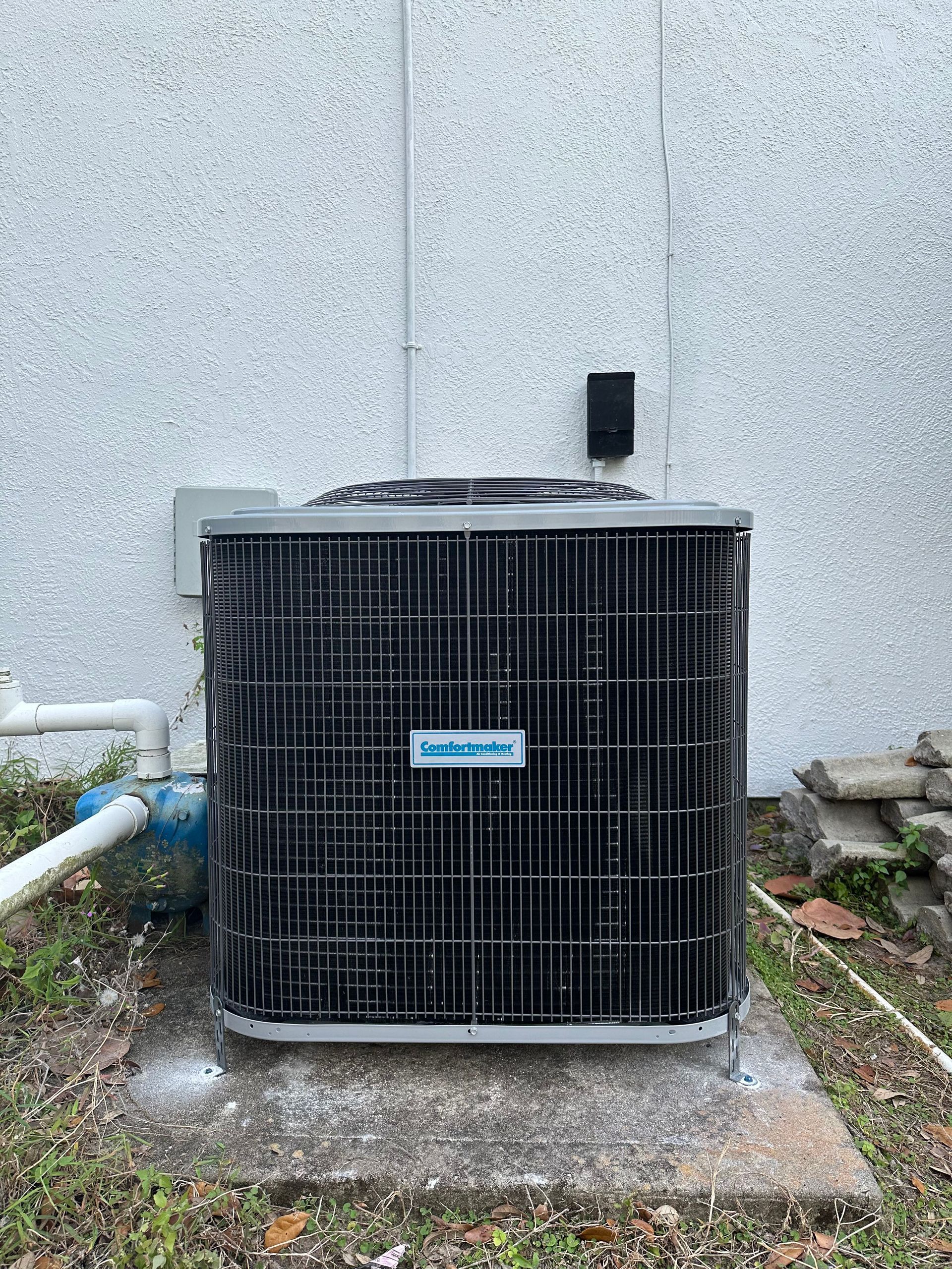 a large air conditioner is sitting outside of a building .