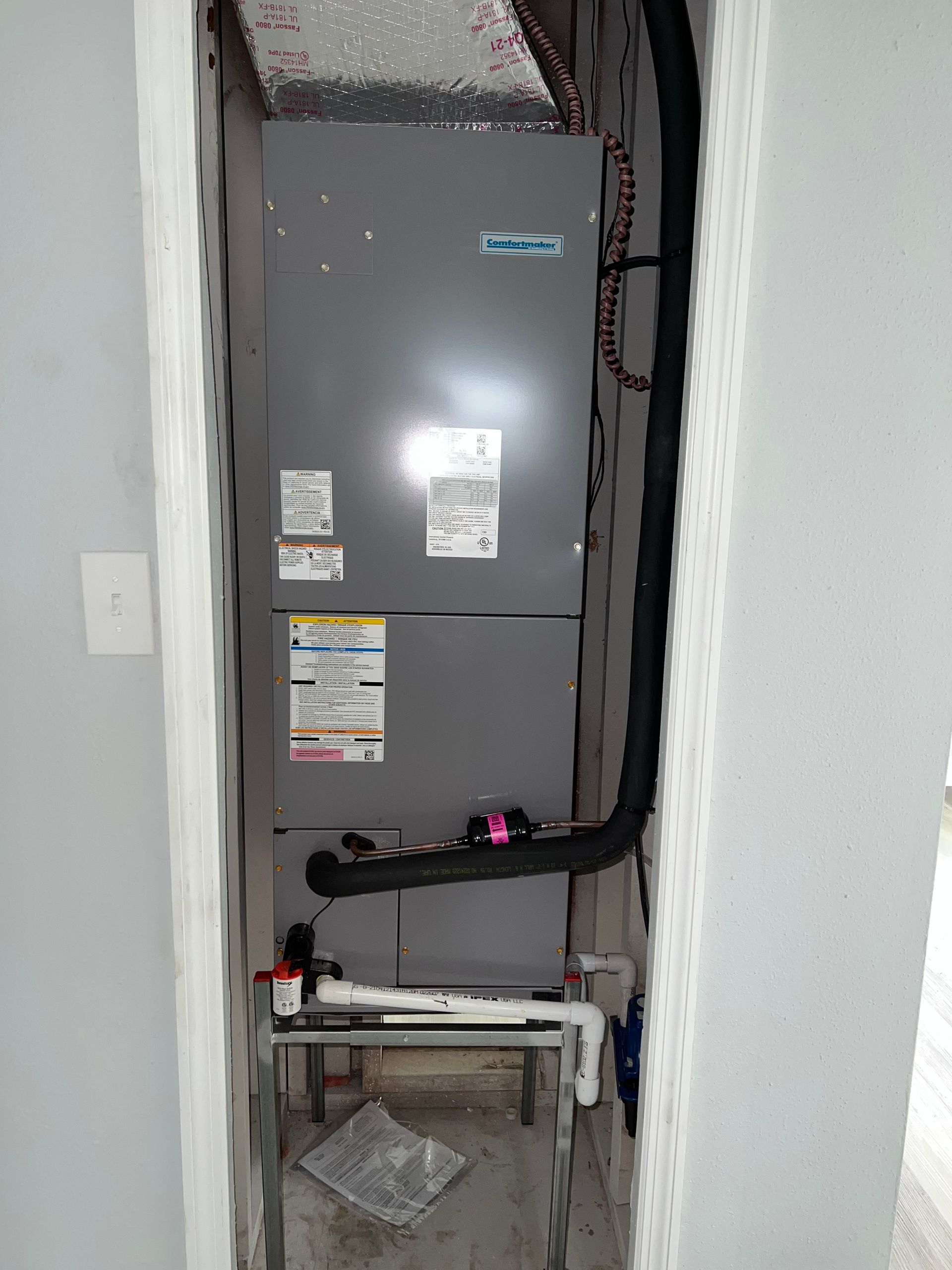 a refrigerator is sitting in a corner of a room next to a wall .