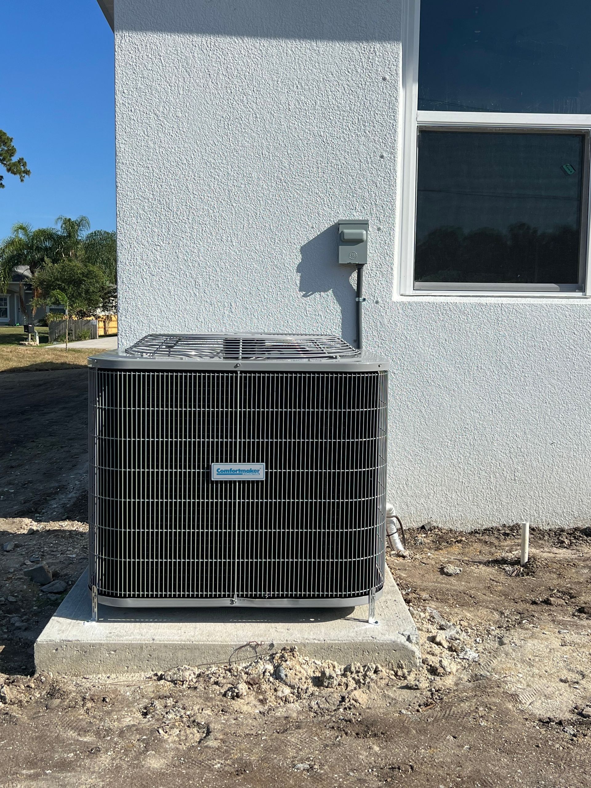 an air conditioner is sitting on the side of a building next to a window .