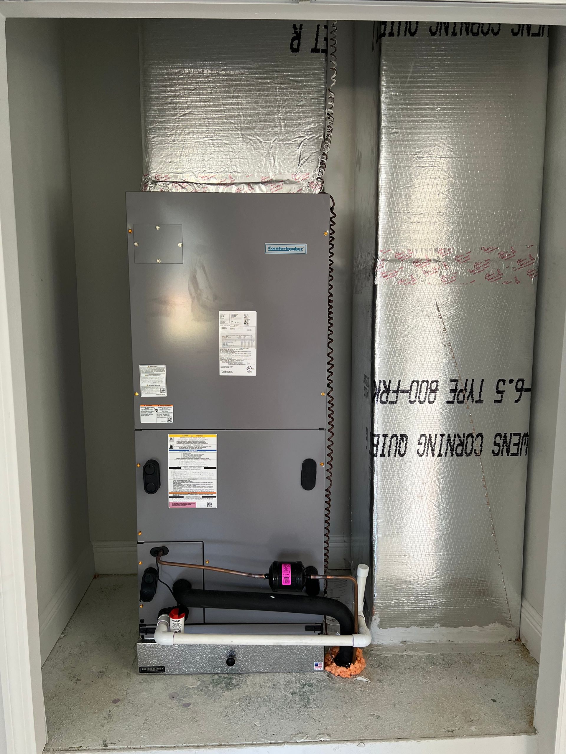 an air conditioner is sitting in a corner of a room .