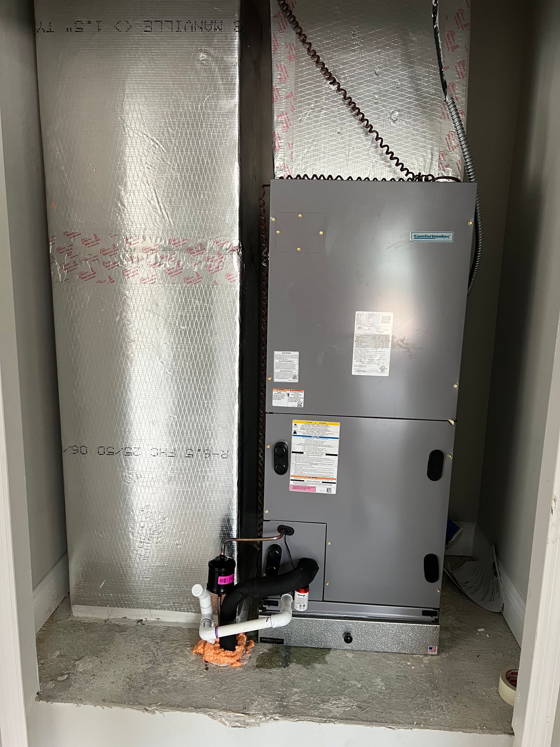 an air conditioner is sitting in a closet next to a wall .