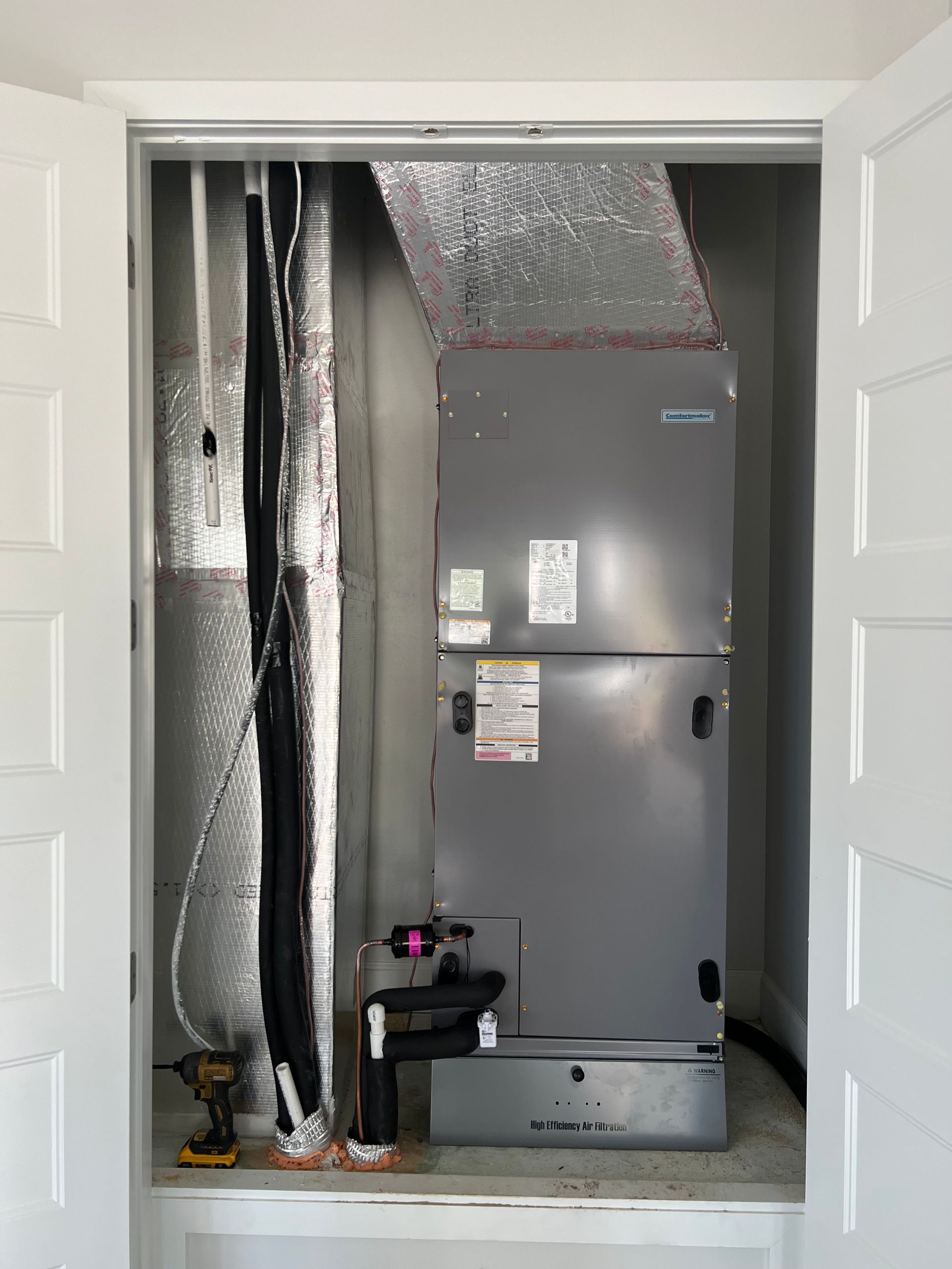 an air conditioner is being installed in a closet .
