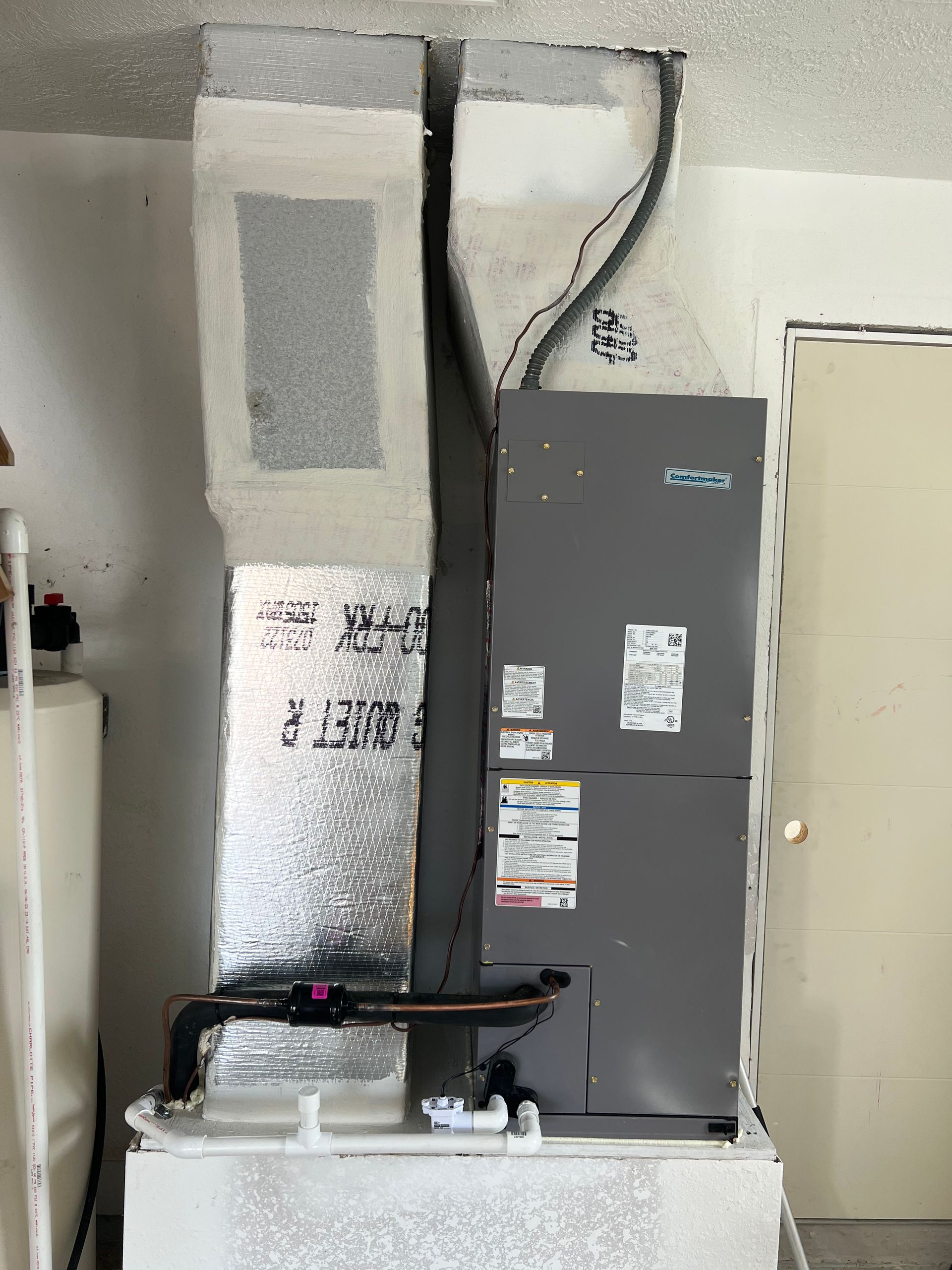 an air conditioner is sitting in a room next to a door .