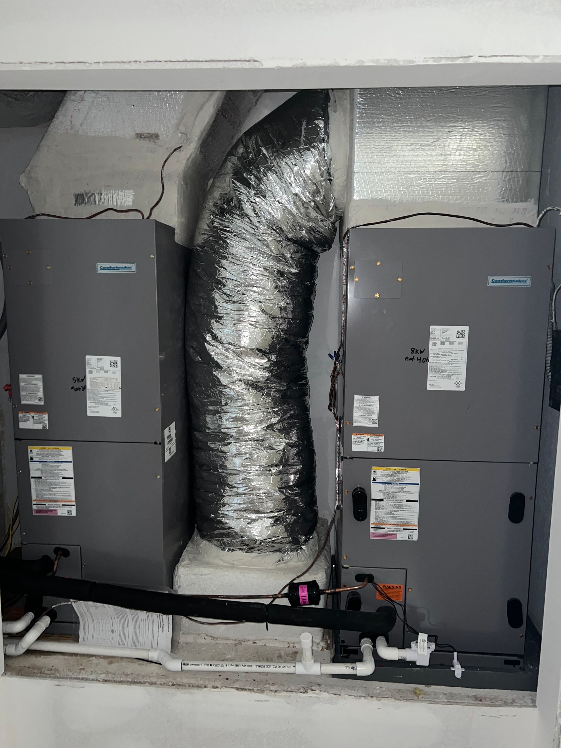 a couple of air conditioners are sitting next to each other in a room .