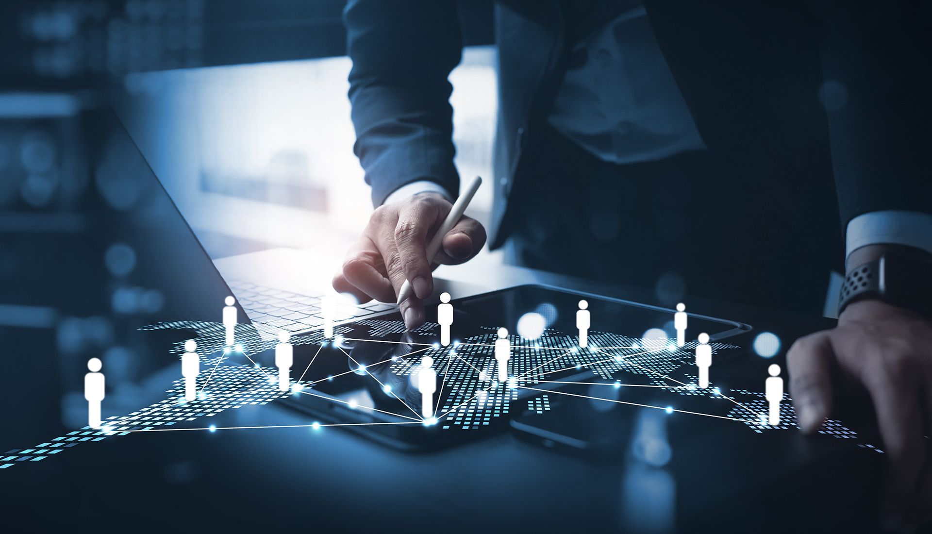 Businessman using a laptop, connected to a network of illuminated human icons, representing a global connection.