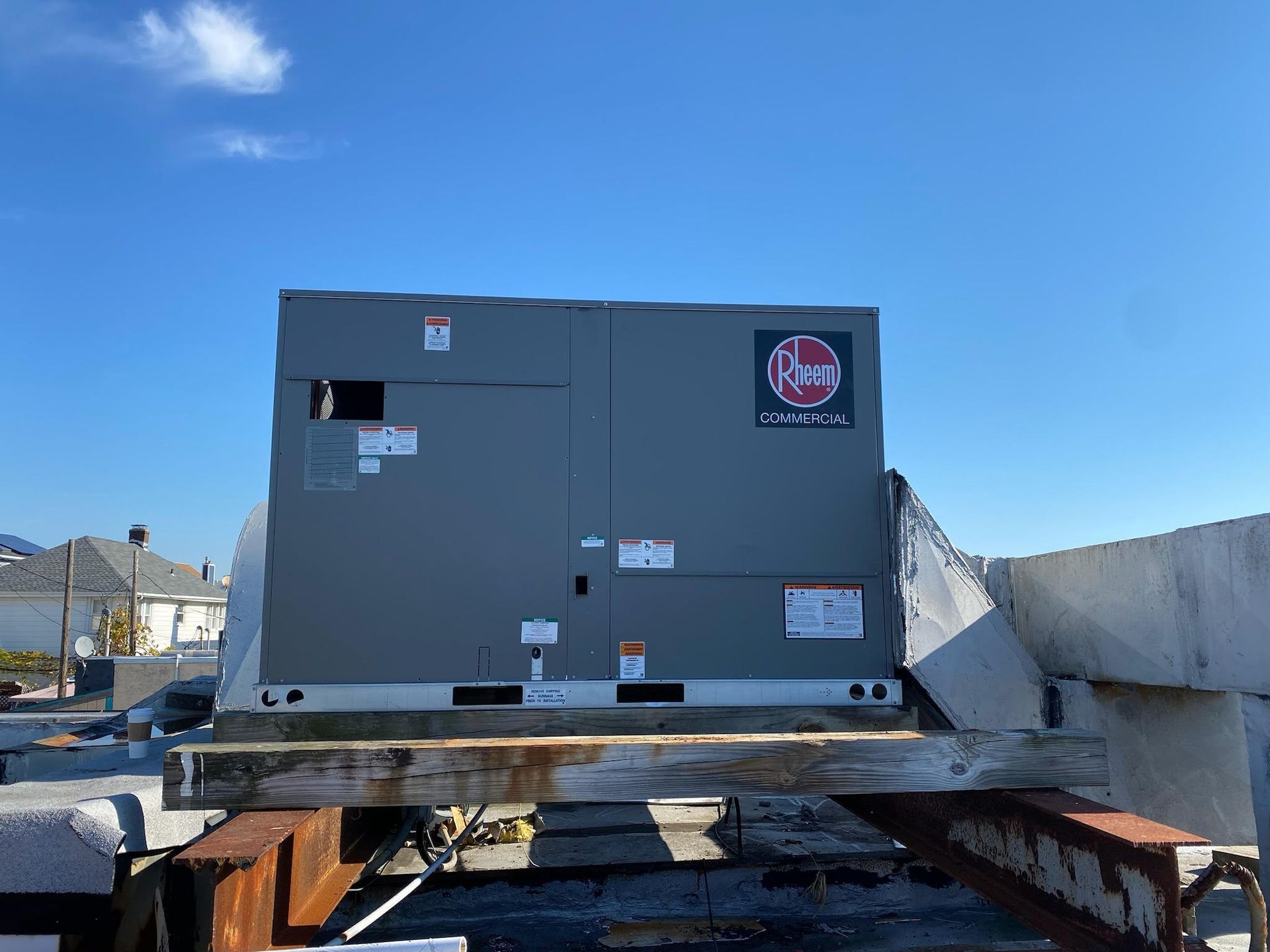 A large gray box is sitting on top of a wooden beam.