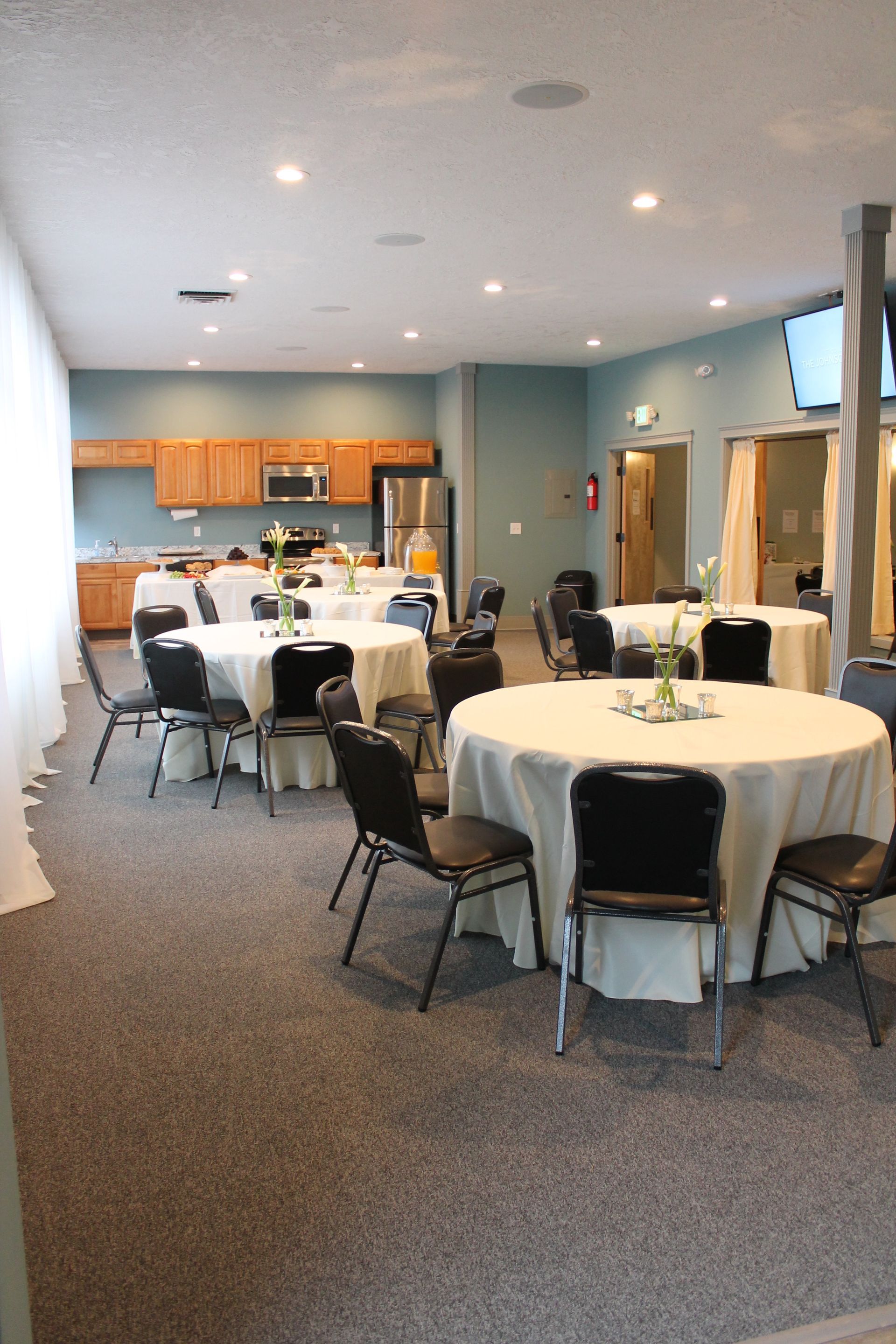 A large room with tables and chairs set up for a party.
