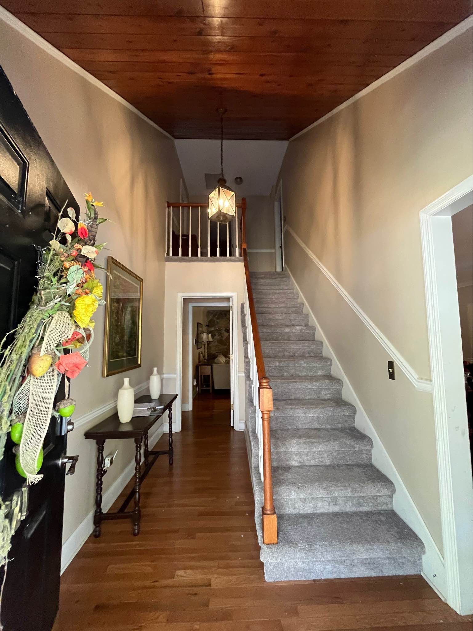 A hallway with stairs leading up to the second floor of a house.