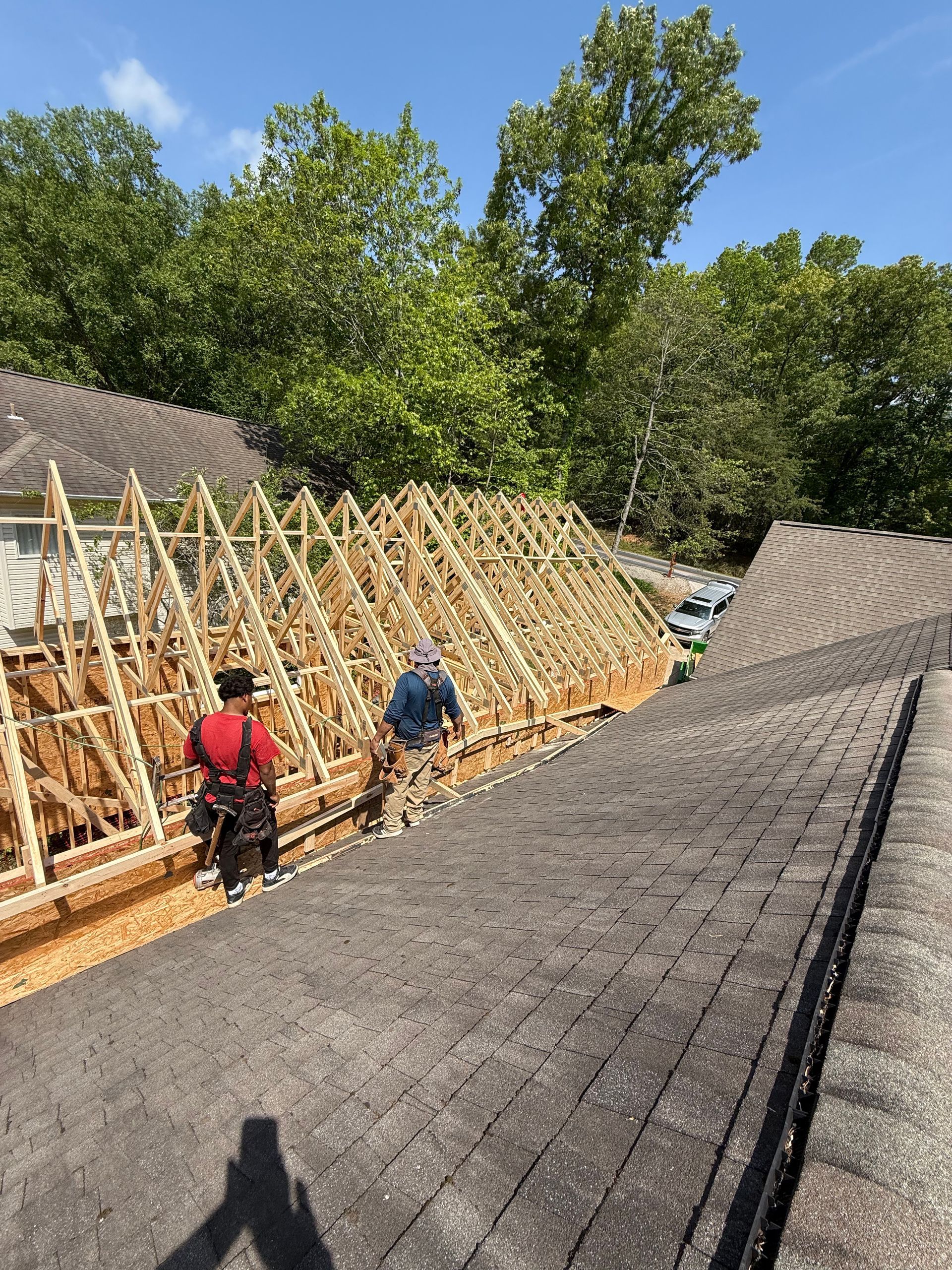 Two men are working on the roof of a house.