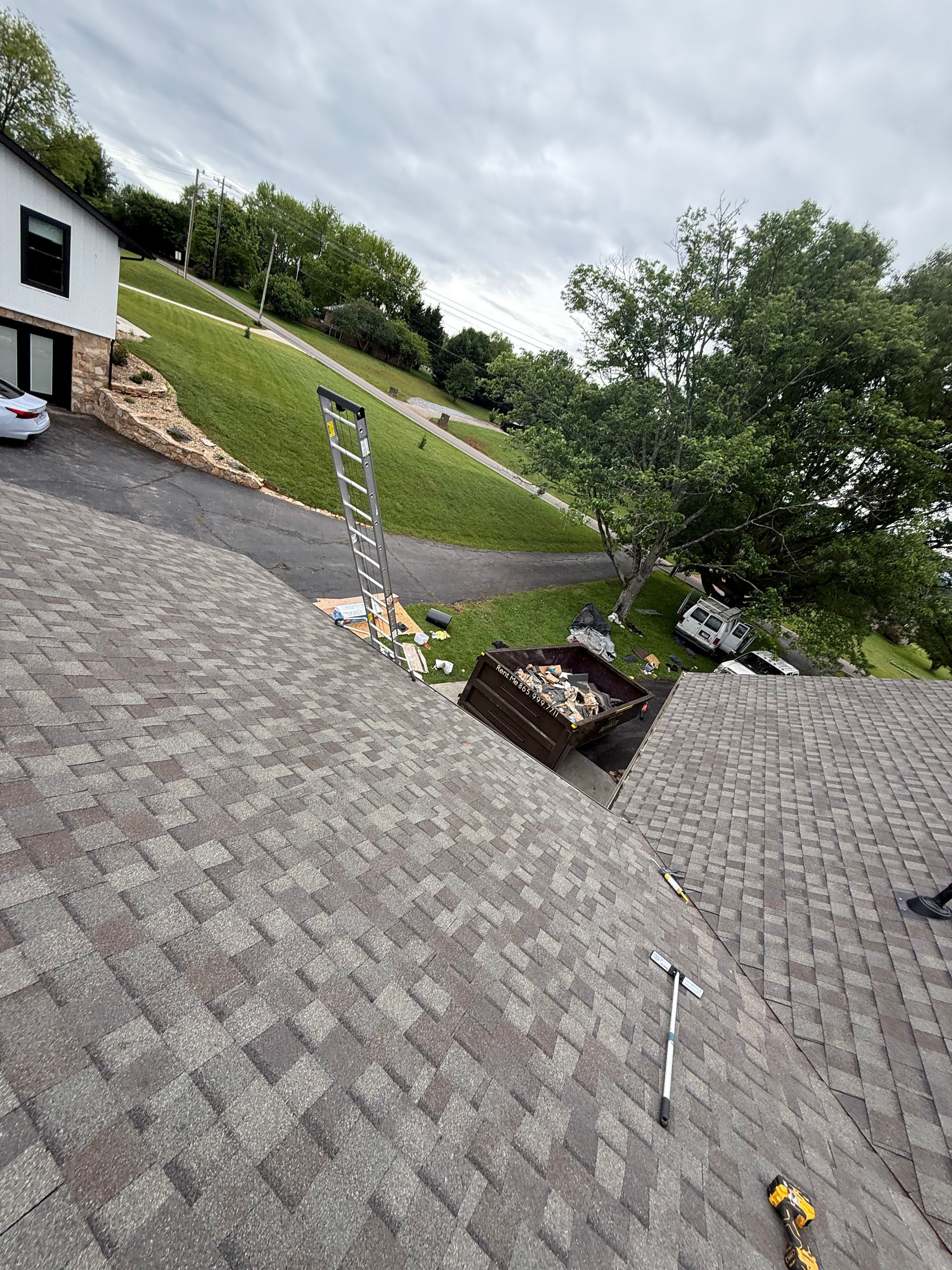 A ladder is sitting on the roof of a house.