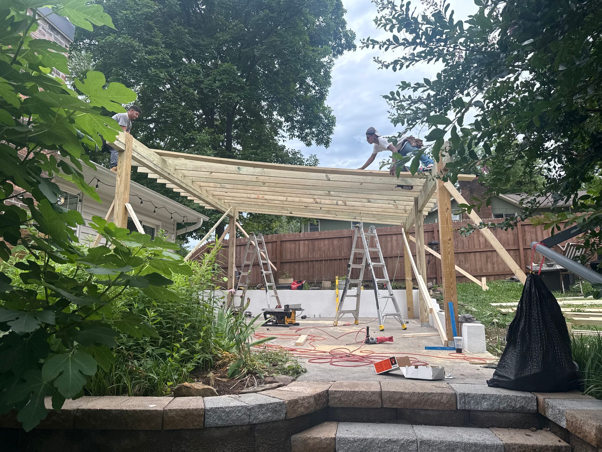 A man is standing on top of a wooden structure in a backyard.