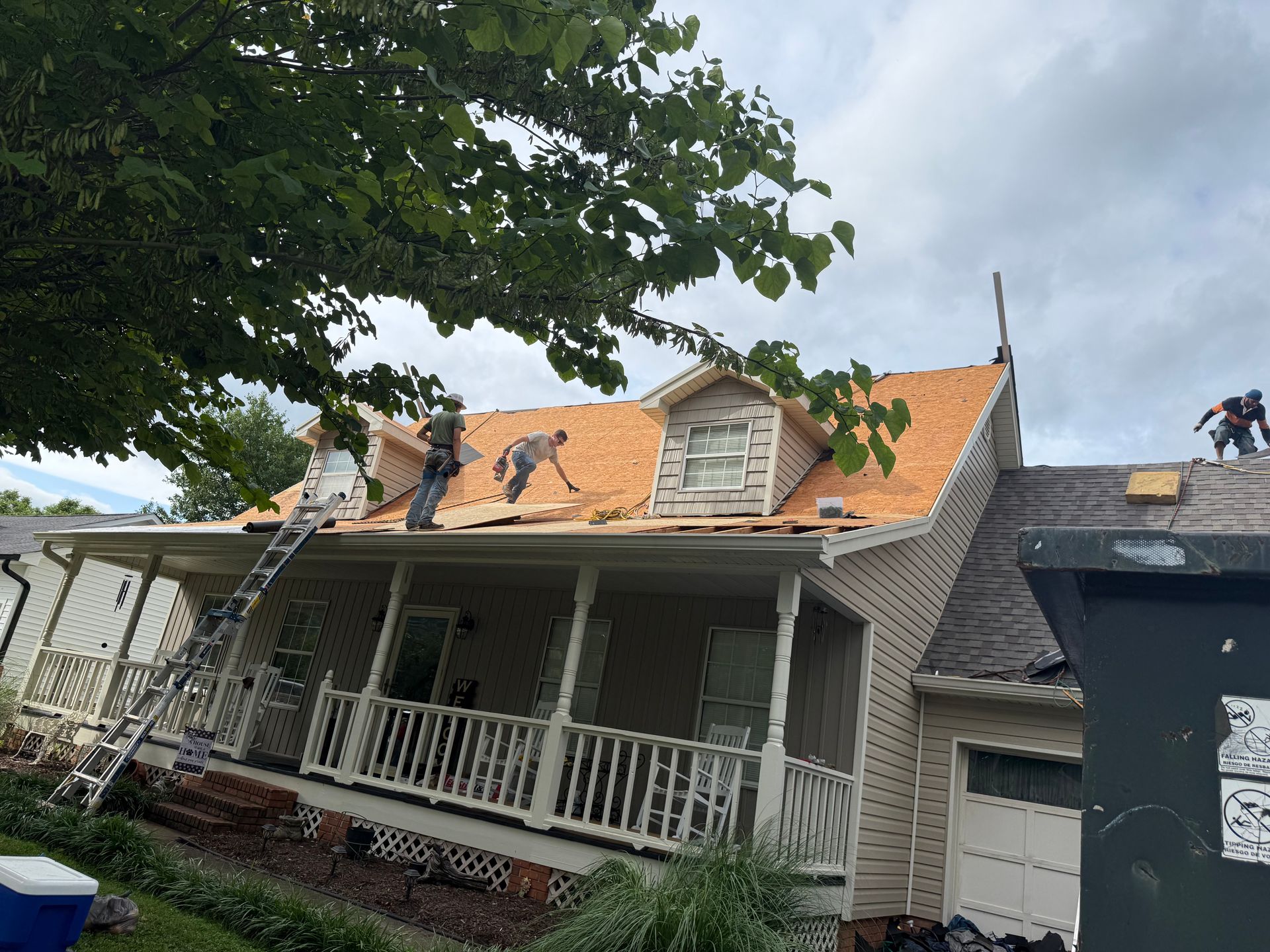 A group of people are working on the roof of a house.