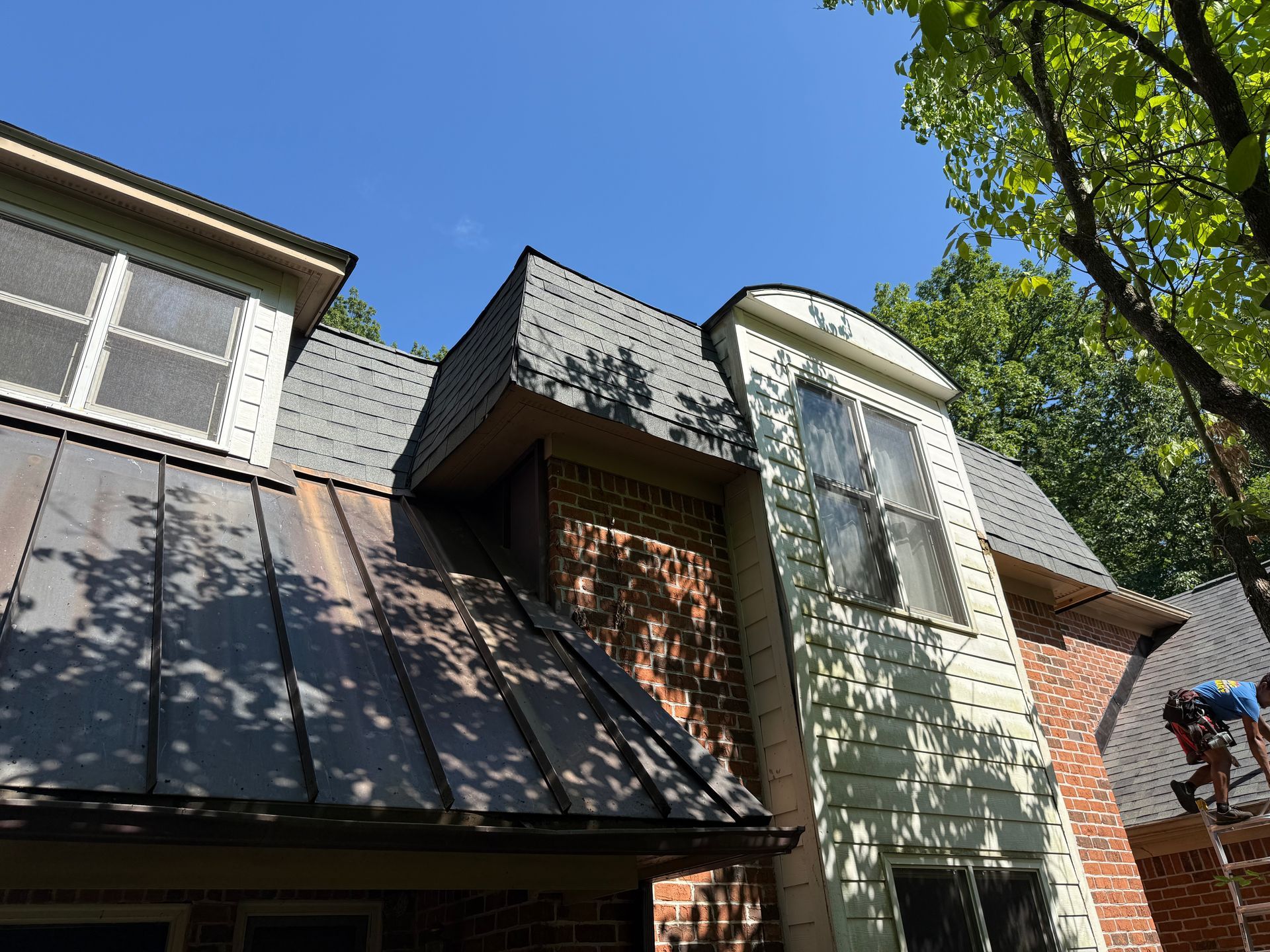 A man is working on the roof of a house.