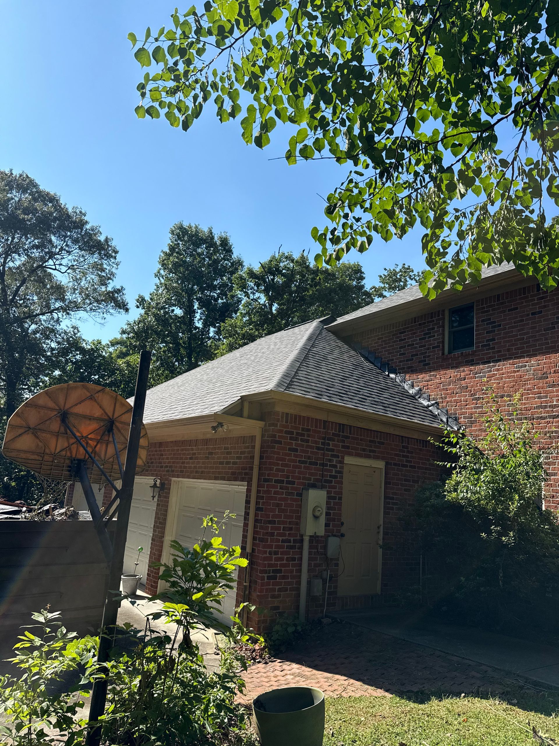 A brick house with a roof that is covered in shingles.