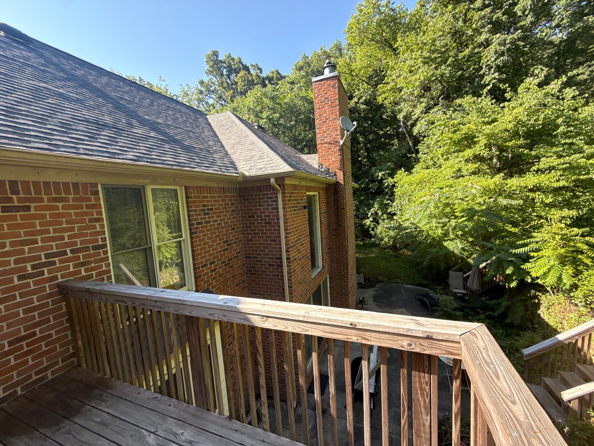 A brick house with a wooden deck in front of it.