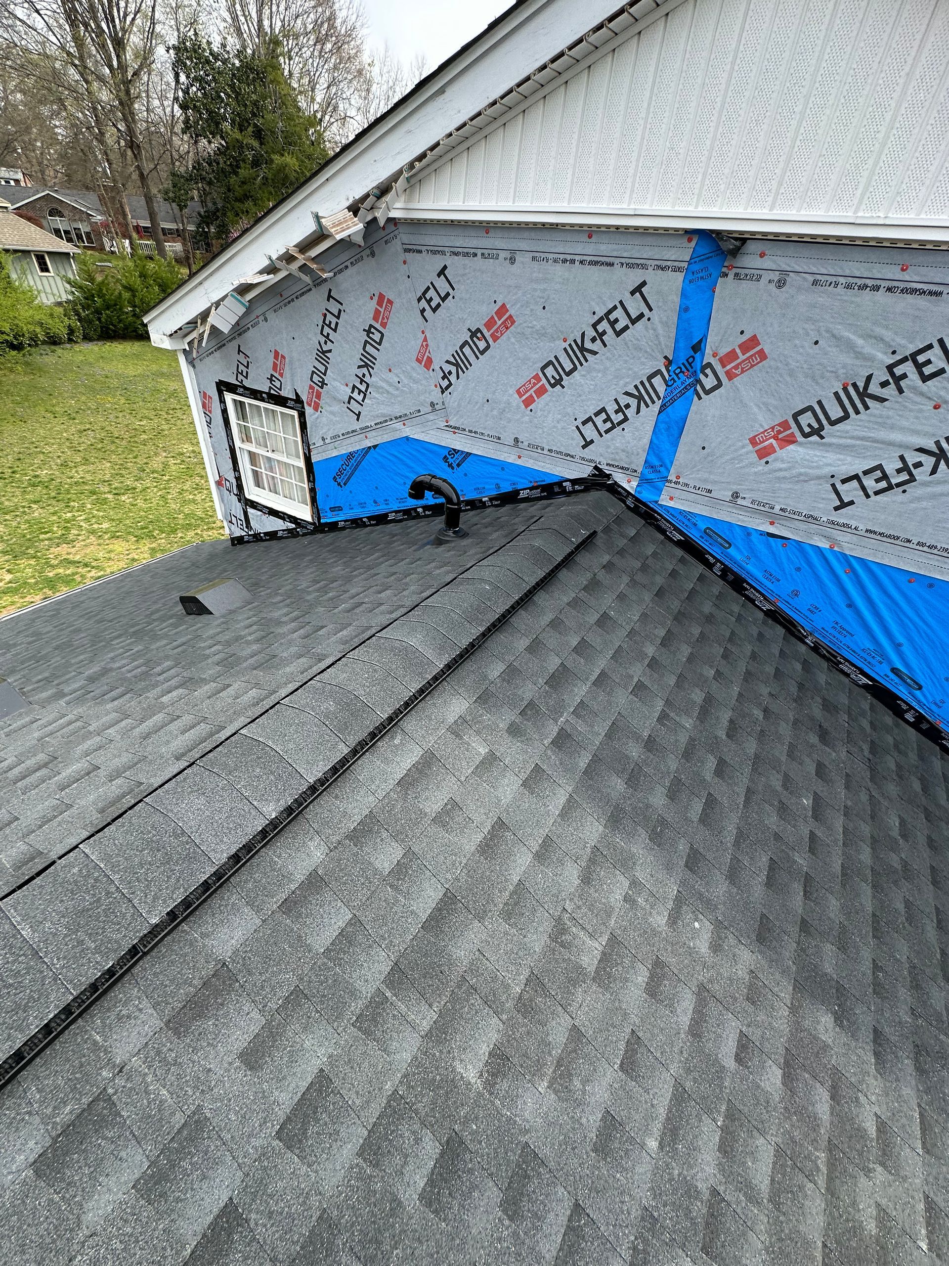 A close up of a roof with a blue tarp on it.