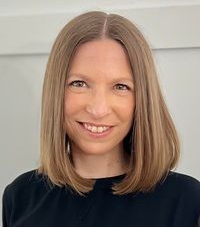 Portrait of Dr. Cristina Meffe (Naturopathic Doctor) smiling, with short brown hair against a white background
