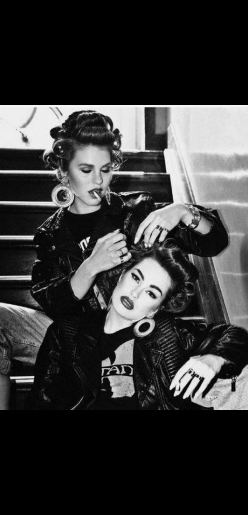 Una foto in bianco e nero di due donne sedute sulle scale