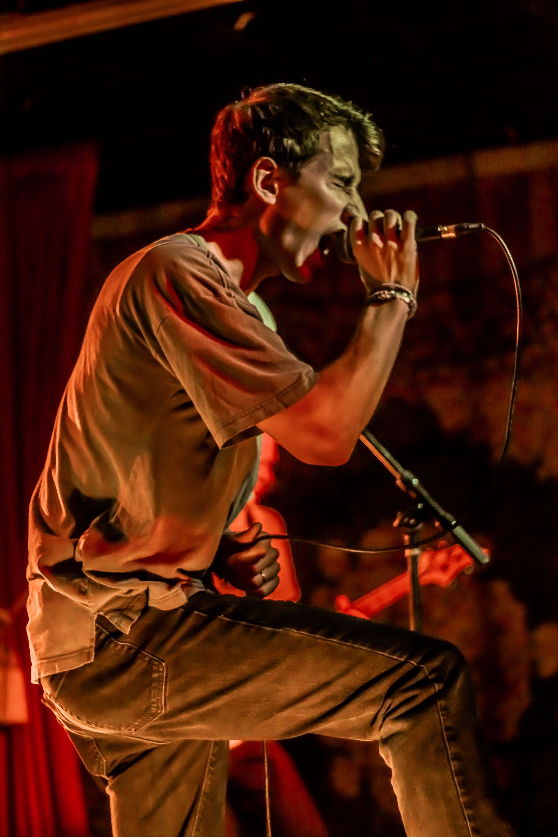 A man is singing into a microphone on a stage.