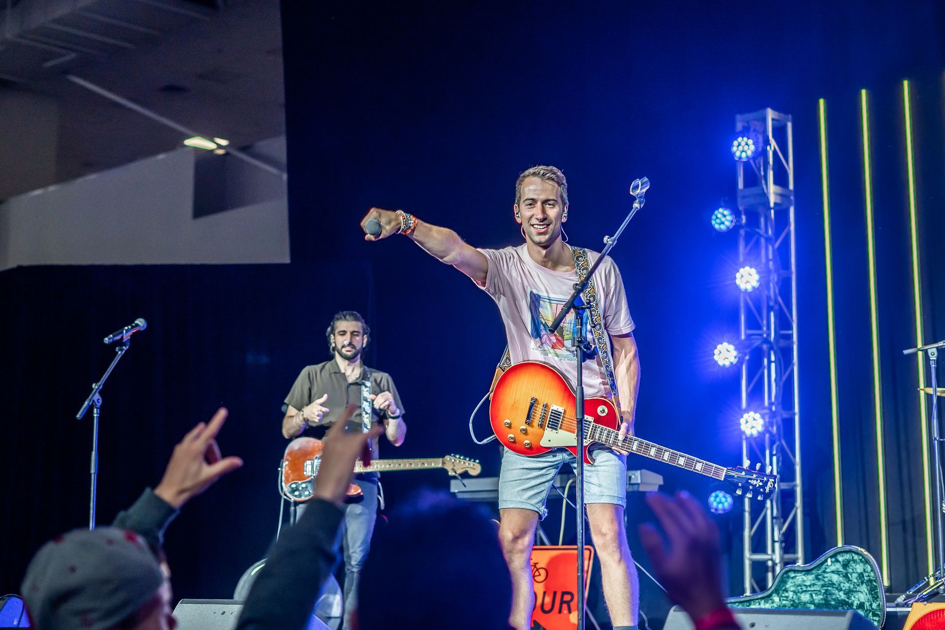 A man is playing a guitar on a stage in front of a crowd.