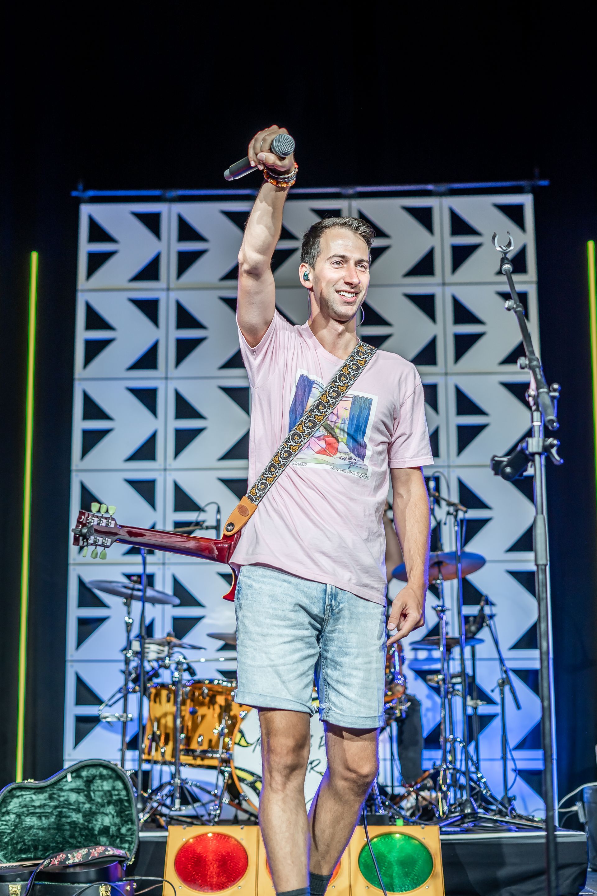 A man is standing on a stage holding a microphone in his hand.