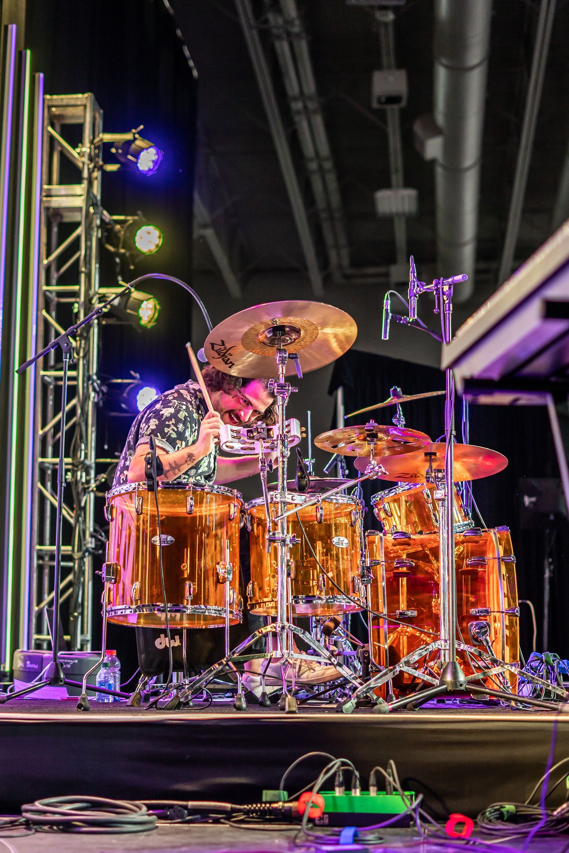A man is playing drums on a stage.