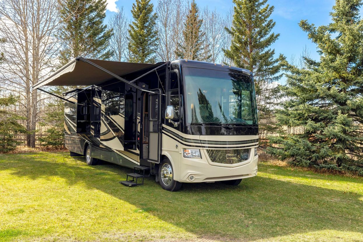 A white rv is parked on the side of a dirt road.