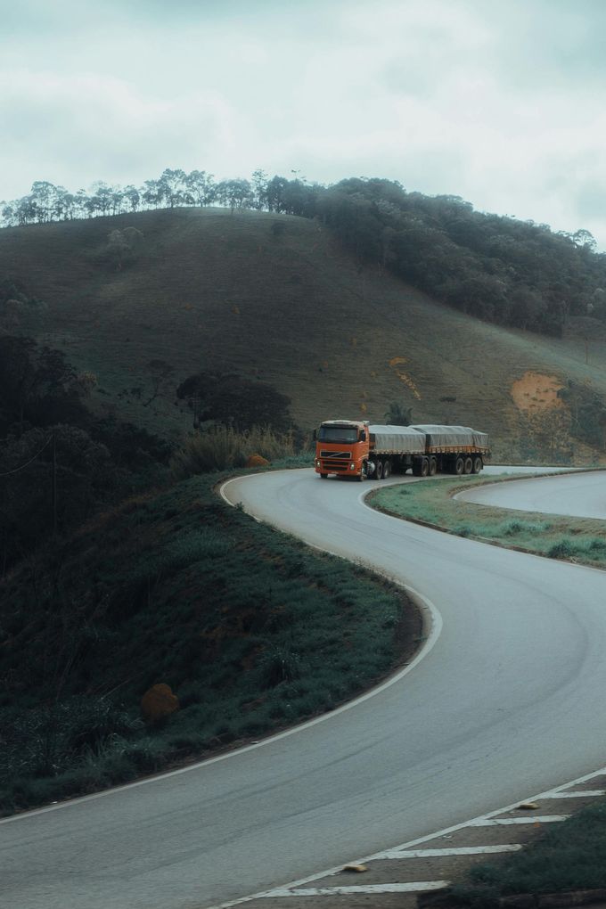 A truck is driving down a curvy road.