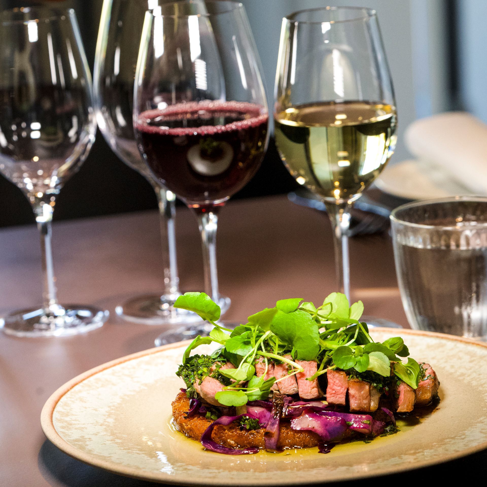 Tallerken med mad med rød- og hvidvinsglas.