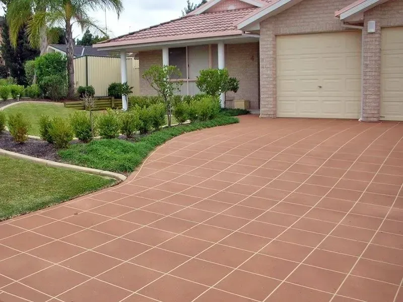A brick house with a tiled driveway in front of it — Concrete Colour Solutions in Morisset, NSW
