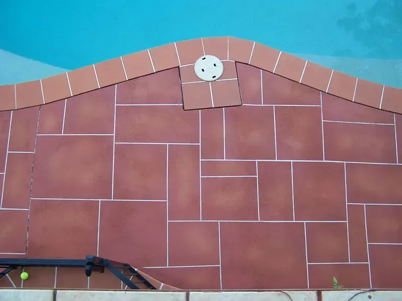 A brick wall with a white circle on top of it — Concrete Colour Solutions in Morisset, NSW