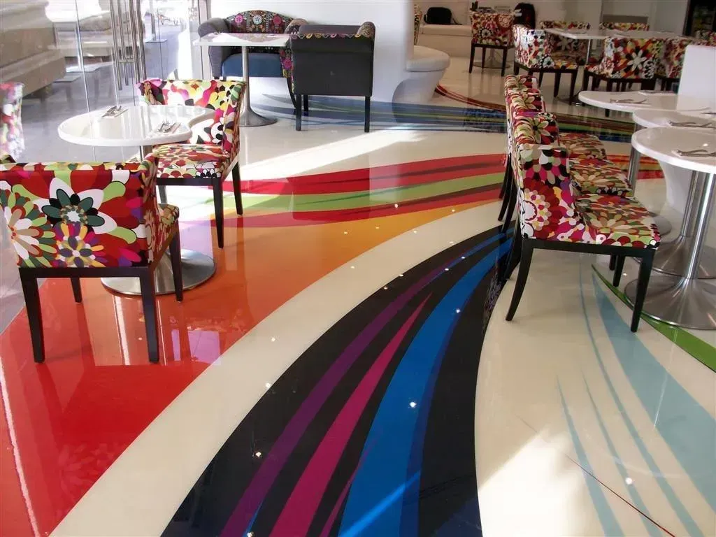 A room with tables and chairs and a rainbow floor — Concrete Colour Solutions in Morisset, NSW