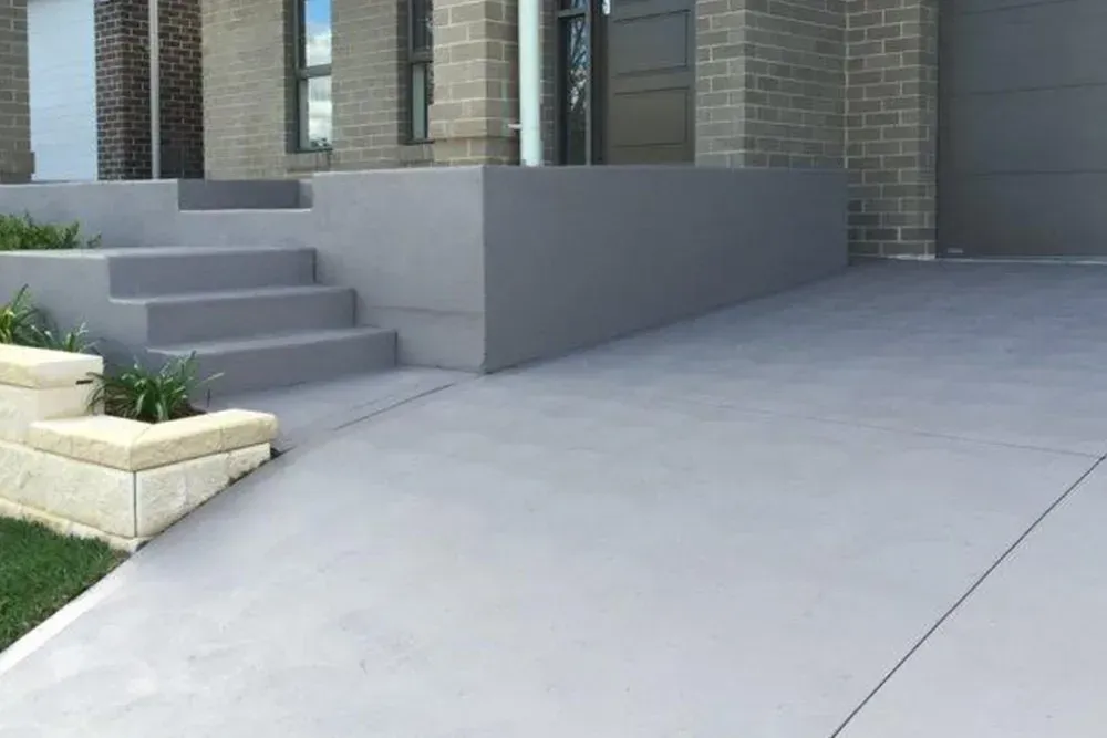 A Concrete Driveway with Stairs Leading up To a House — Concrete Colour Solutions in Morisset, NSW