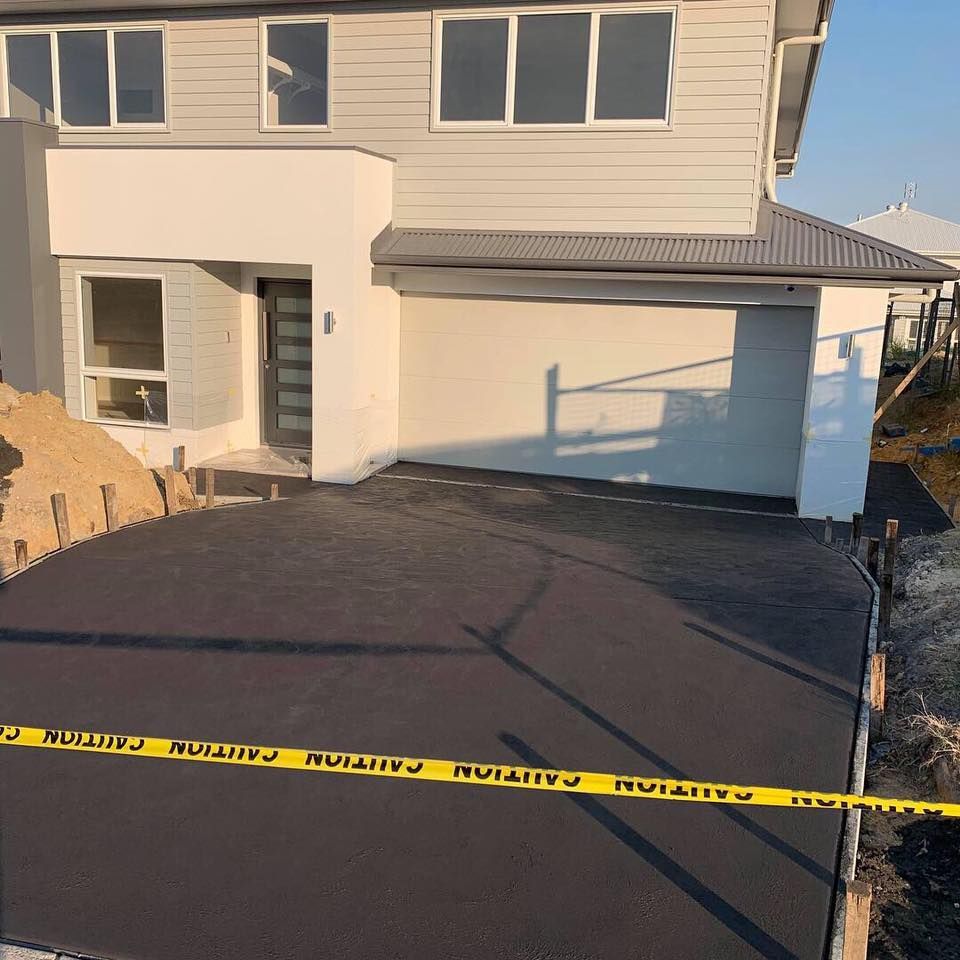 A Driveway Is Being Built in Front of A House — Concrete Colour Solutions in Morisset, NSW