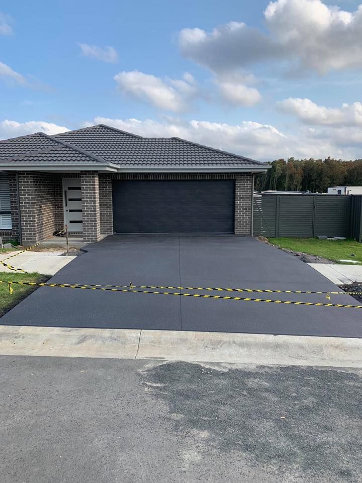 A House with A Concrete Driveway in Front of It — Concrete Colour Solutions in Morisset, NSW