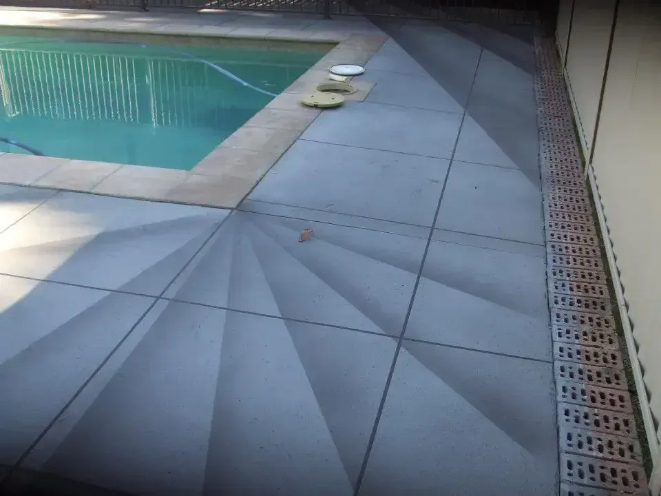 A Swimming Pool Is Surrounded by A Tiled Floor — Concrete Colour Solutions in Morisset, NSW