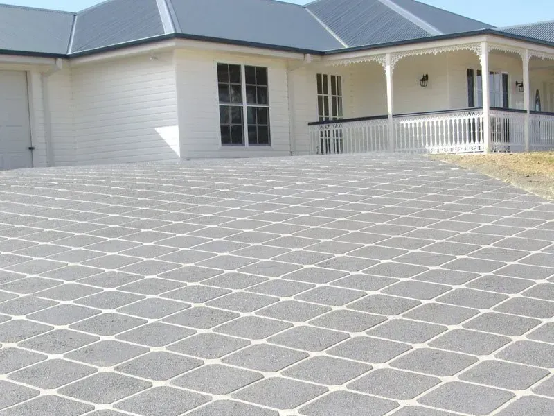 A large white house with a large driveway in front of it — Concrete Colour Solutions in Morisset, NSW