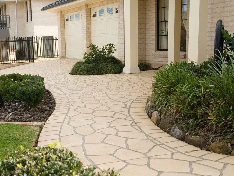 A stone walkway leading to a white brick house — Concrete Colour Solutions in Morisset, NSW