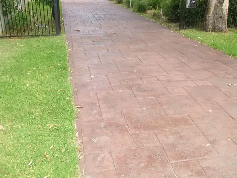 A Brick Driveway Leading to A Gate with Grass on The Side — Concrete Colour Solutions in Morisset, NSW