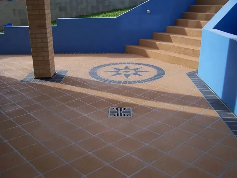 A tiled floor with a circular design on it — Concrete Colour Solutions in Morisset, NSW