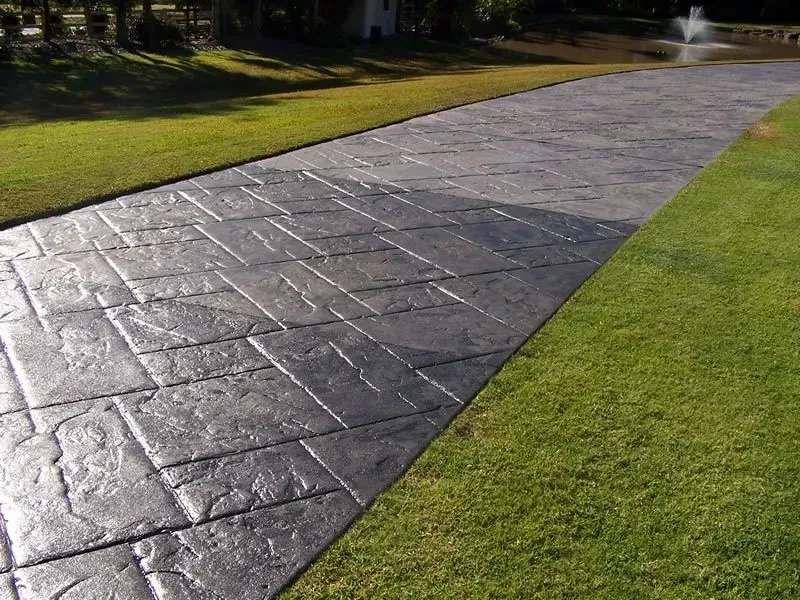 A concrete driveway with a fountain in the background — Concrete Colour Solutions in Morisset, NSW