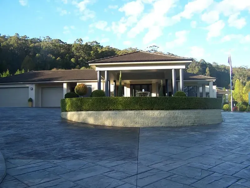 A large house with a circular driveway in front of it — Concrete Colour Solutions in Morisset, NSW