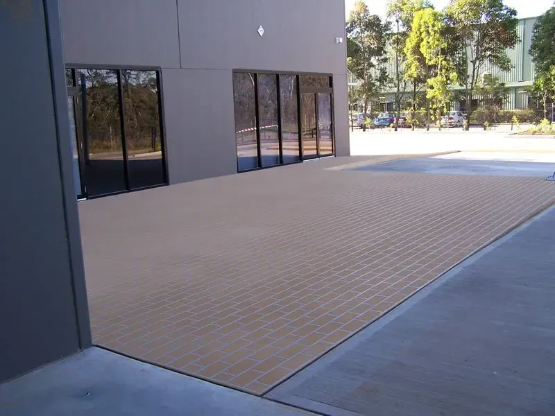A large building with a lot of windows and a patio in front of it — Concrete Colour Solutions in Morisset, NSW