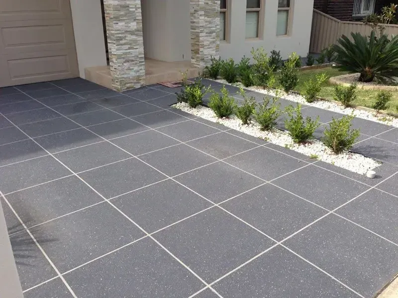 A driveway with a few plants in the middle of it — Concrete Colour Solutions in Morisset, NSW