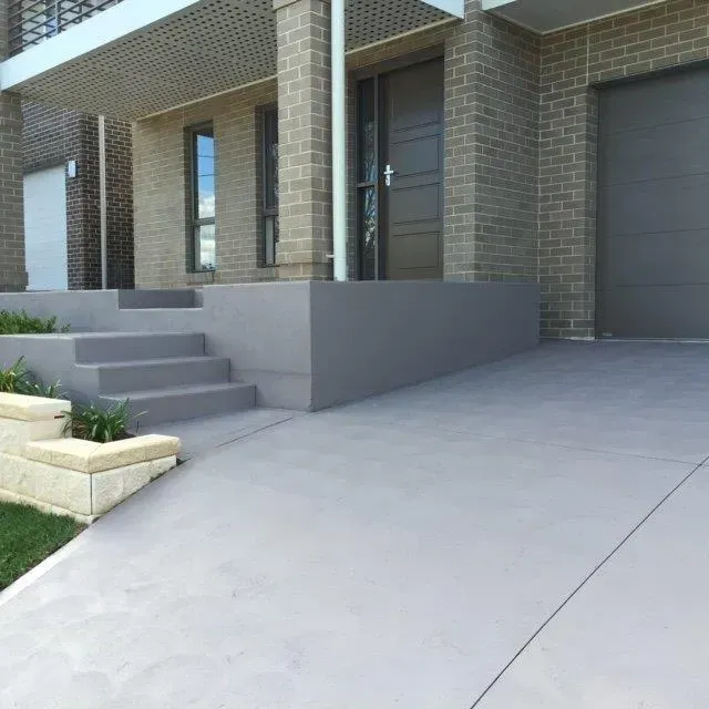 A brick house with a concrete driveway and stairs — Concrete Colour Solutions in Morisset, NSW