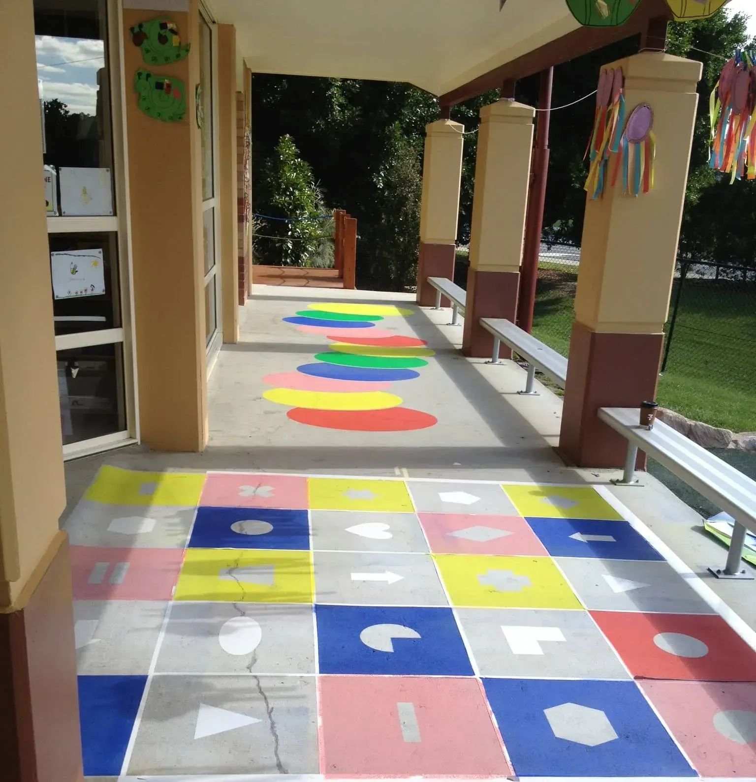 A patio with a colourful checkered floor and benches — Concrete Colour Solutions in Morisset, NSW
